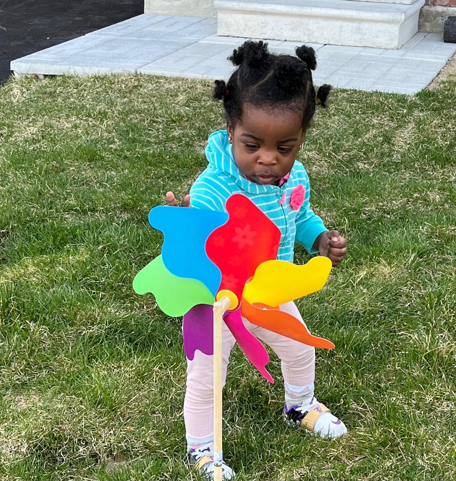 1 infant playing with a toy windmill