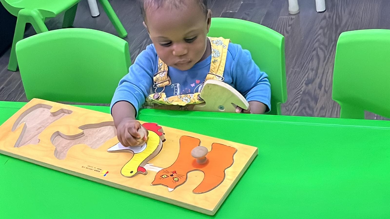 1 infant playing with cut out shape board
