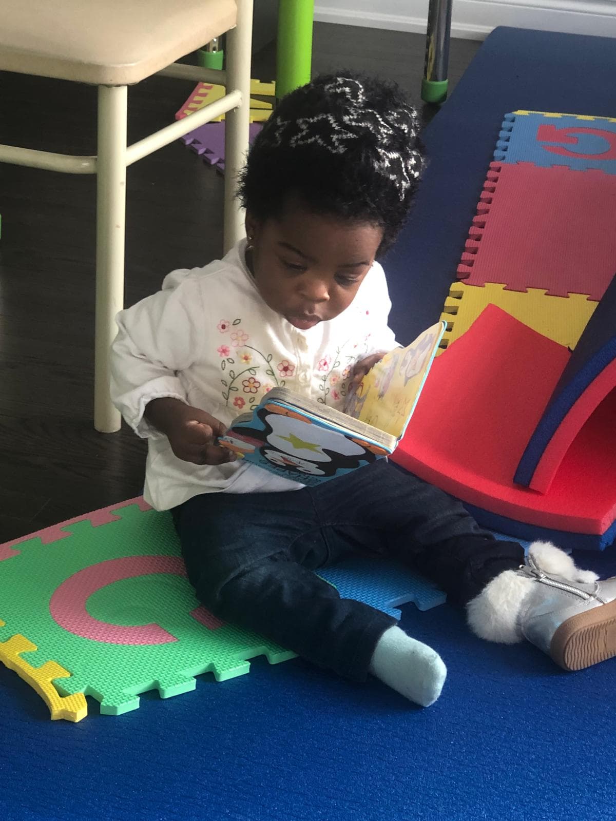 1 infant sitting and reading