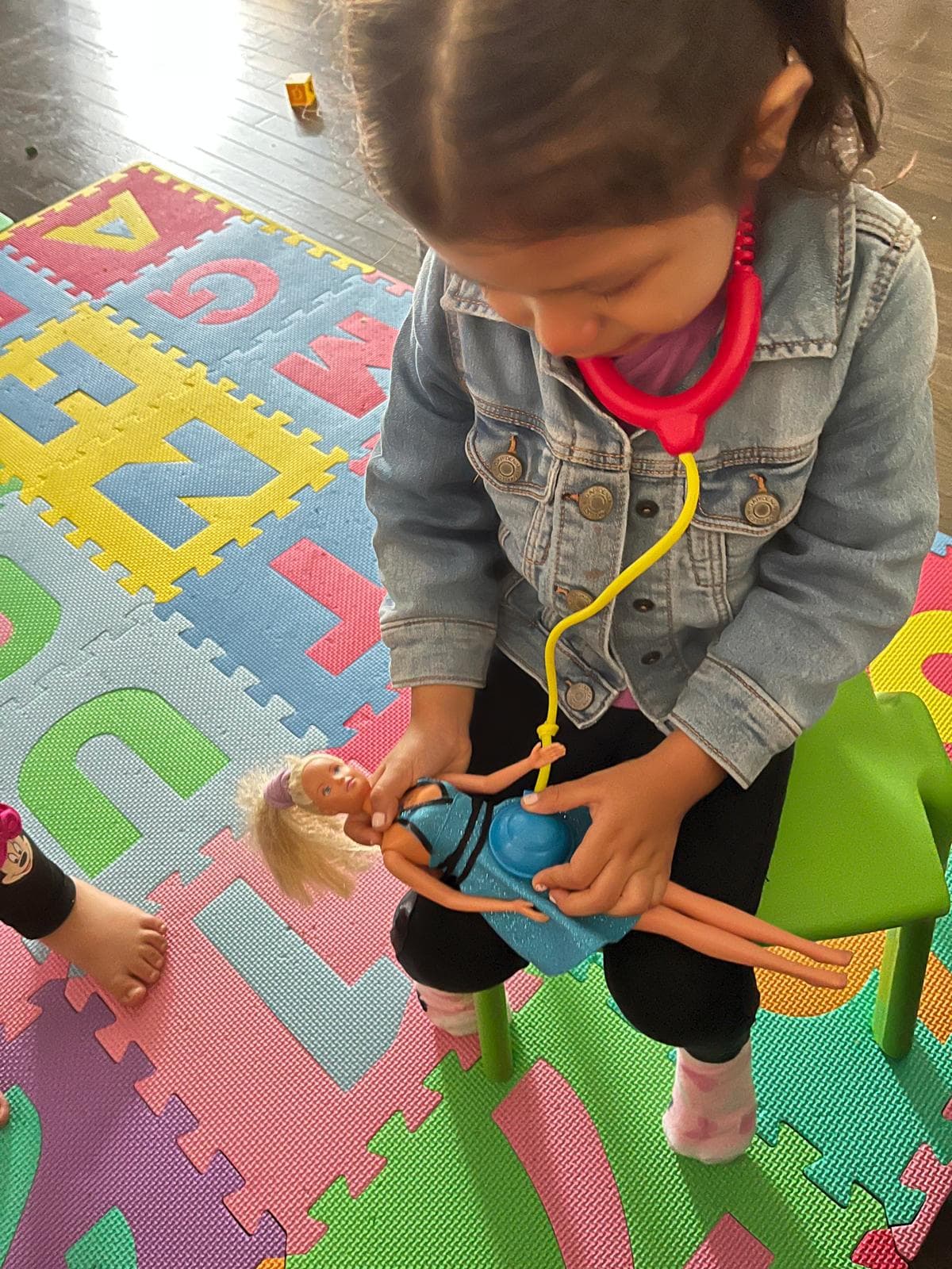1 kid playing doctor with a doll