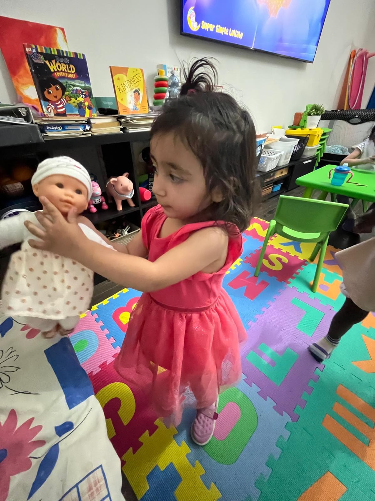 1 kid showing baby doll smiling