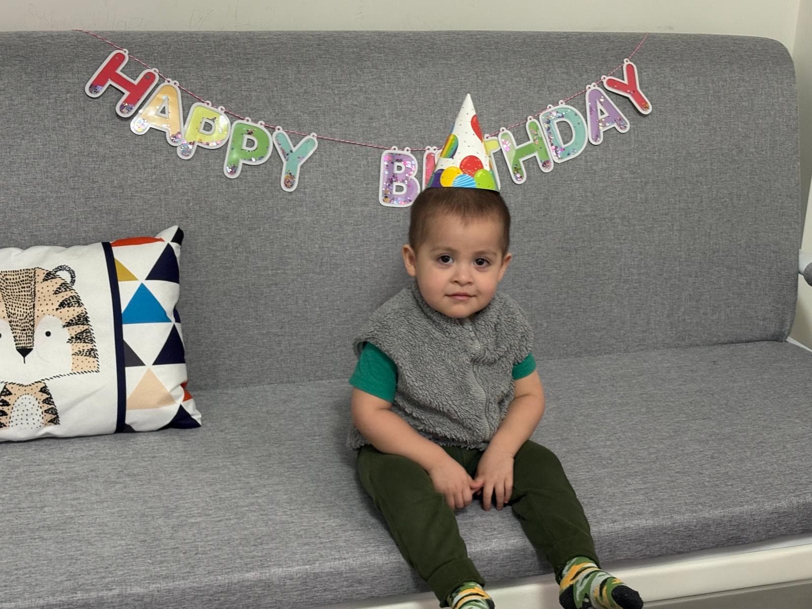 1 kid smiling for camera in front of birthday celebration