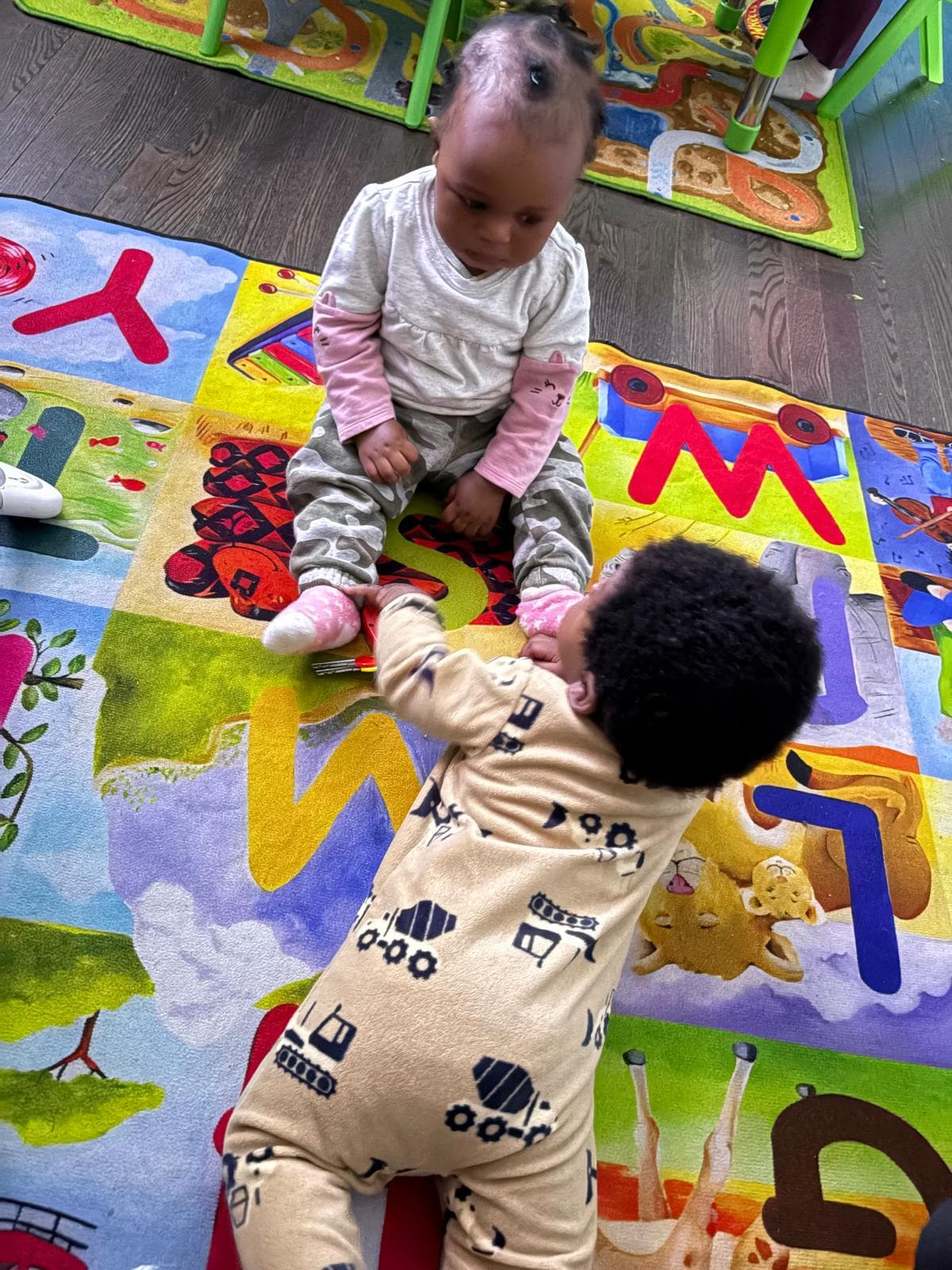 2 infants crawling and playing together