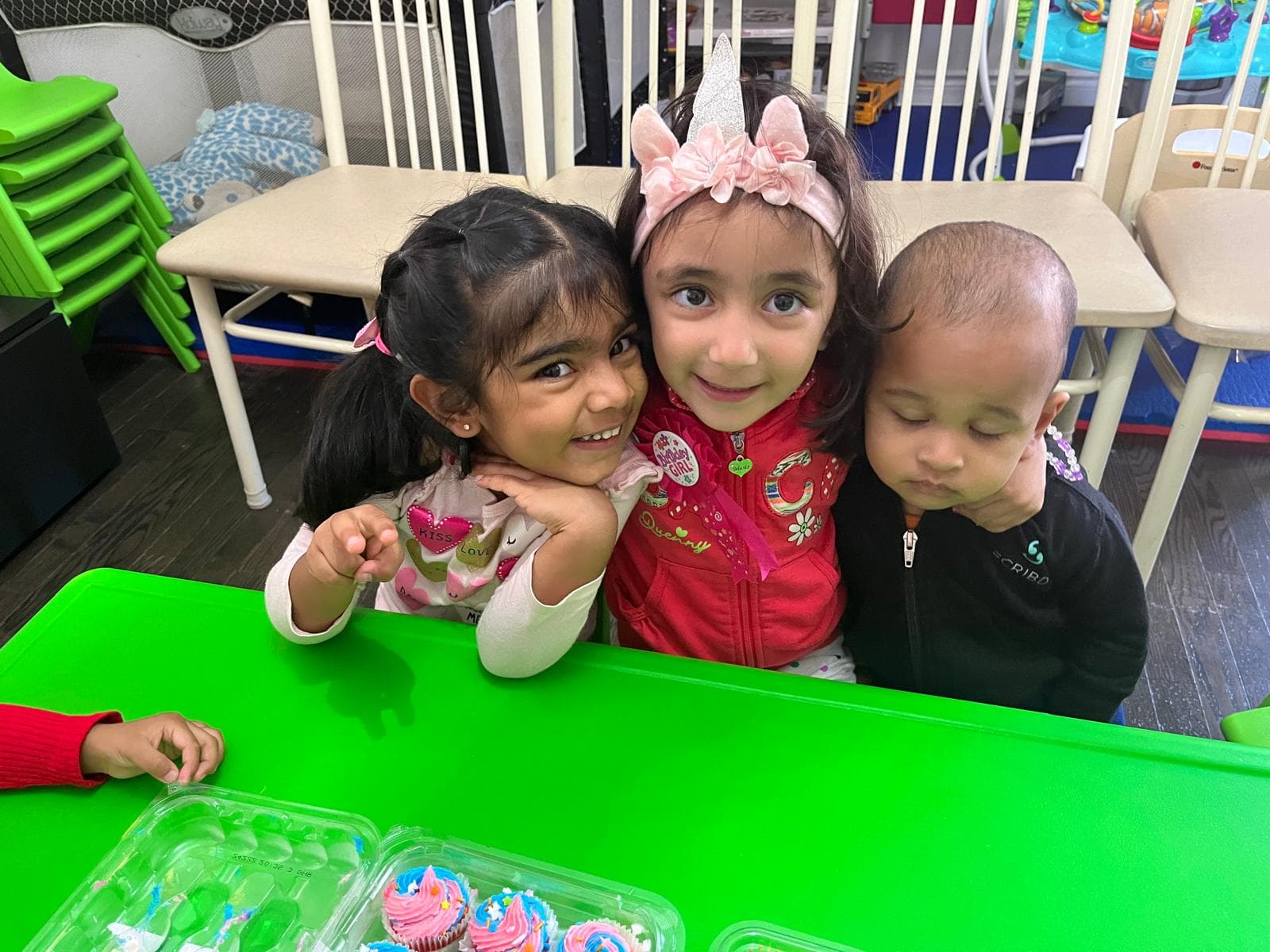 3 kids hugging and smiling for the camera