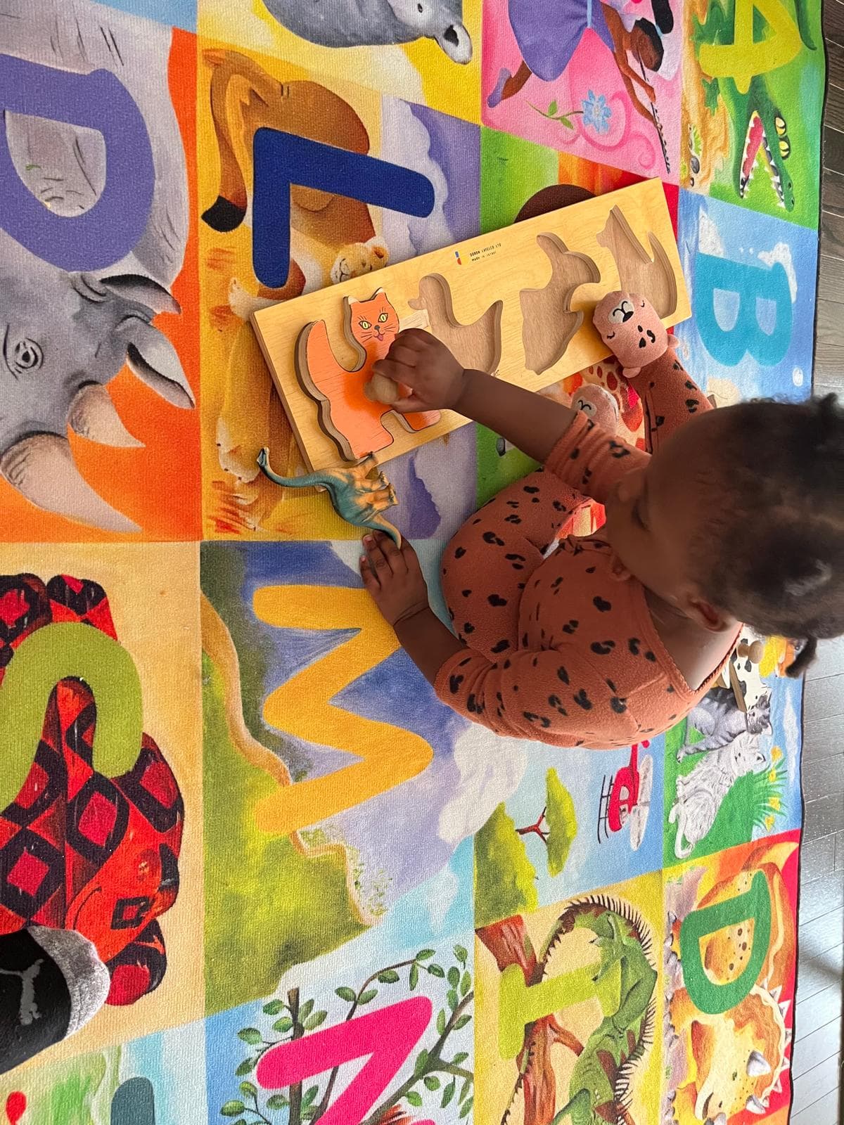 Infant playing with cut out shape board