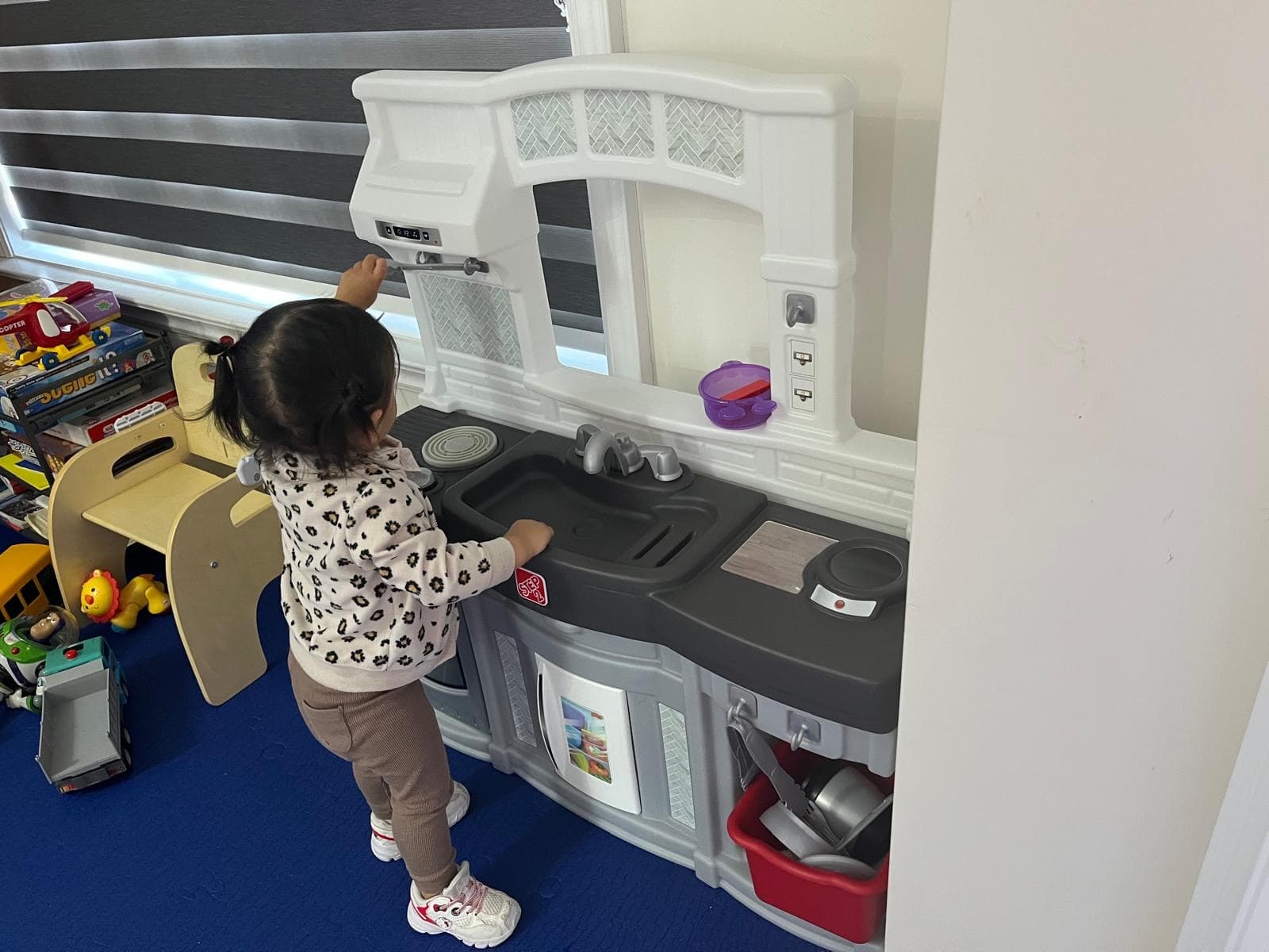 Kid playing with toy kitchen